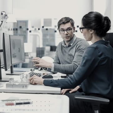 Man and woman talking at desk.